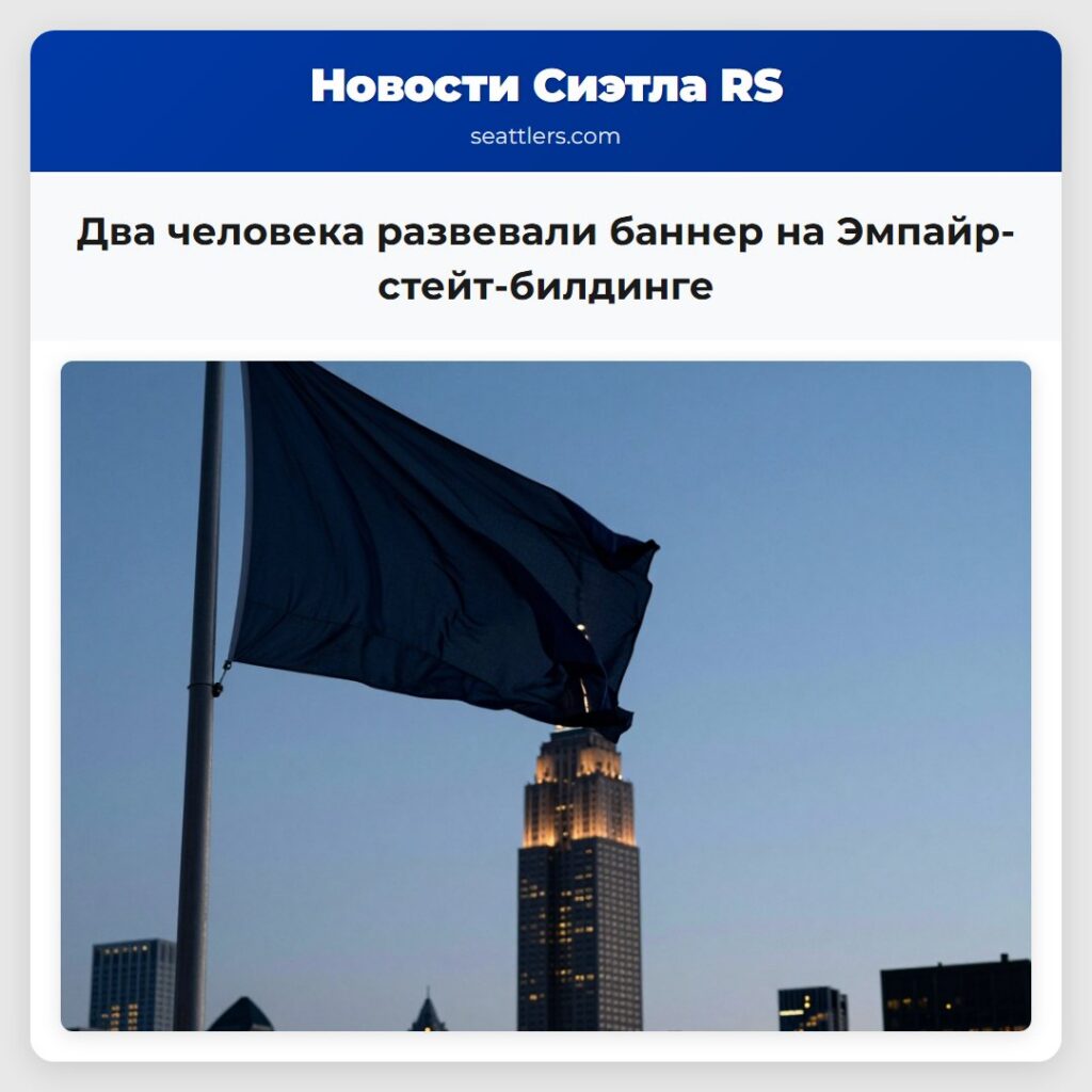Два человека развевали баннер на